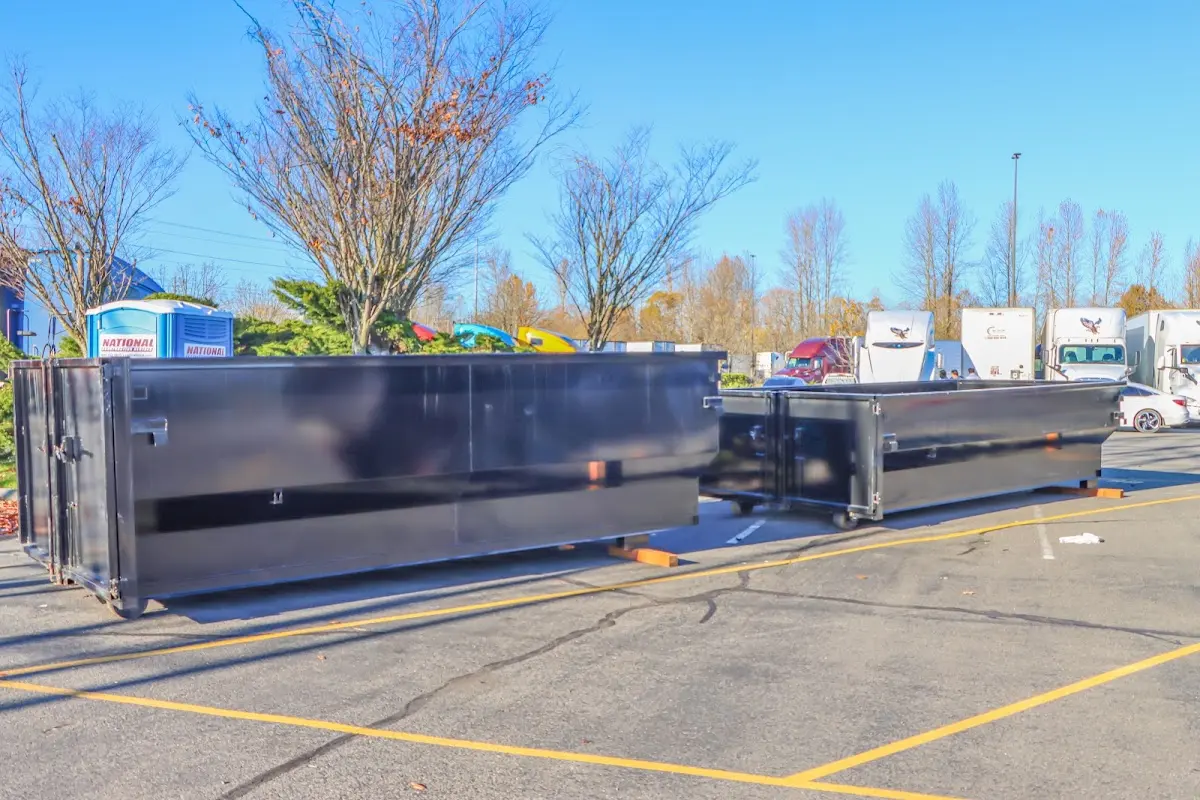 Professional dumpster rental service with roll-off container on residential driveway in Victoria